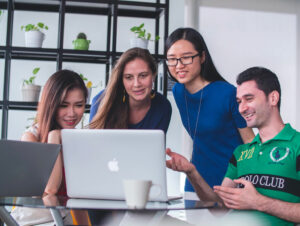 A group of people gathered around a laptop.